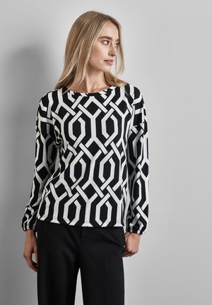 Langsleeve top met een geometrisch zwart-wit patroon, ronde hals en geplooide manchetten. Gemaakt van een zachte, gestructureerde stof.