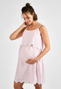 Růžové a bílé pruhované těhotenské šaty se zdvojeným živůtkem a detailem krajek na spodním lemu. Mají tenké ramínka a volný střih.