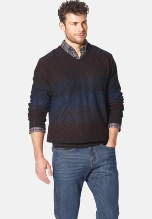 Dark blue and maroon patterned knit sweater with a V-neck, textured design, ribbed cuffs, and waistband, layered over a checked shirt.