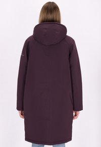 Langer lila Mantel mit Kapuze, glatte Textur, leichter Glanz und seitlichen Taschen. Hat ein Markenakzent auf dem linken Ärmel.