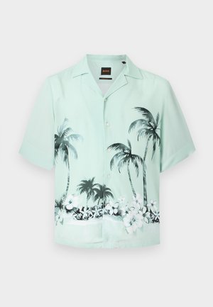 Φωτεινό πράσινο πουκάμισο με κοντά μανίκια και κουμπιά, με μαύρο και λευκό μοτίβο φοίνικα και τροπικά λουλούδια στο κάτω μέρος.