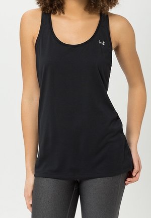 Kobieta ubrana w czarny sportowy top bez rękawów z małym logo Under Armour na piersi, w połączeniu z ciemnoszarymi legginsami.