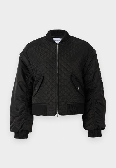 Giubbotto bomber nero con texture trapuntata, polsini e orlo a coste, tasche laterali e chiusura frontale con zip. Finitura leggermente lucida.