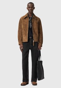 Ruskea mokkanahkatakki vetoketjulla, musta t-paita ja mustat farkut. Asun täydentävät ruskeat saappaat ja musta olkalaukku.