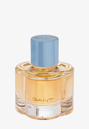Klarer Glasparfümflakon mit golden-gelblichem Inhalt, hellblauem zylindrischen Verschluss und "GANT"-Logo auf der Vorderseite.