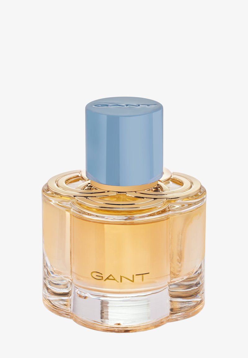 Klarer Glasparfümflakon mit golden-gelblichem Inhalt, hellblauem zylindrischen Verschluss und "GANT"-Logo auf der Vorderseite.