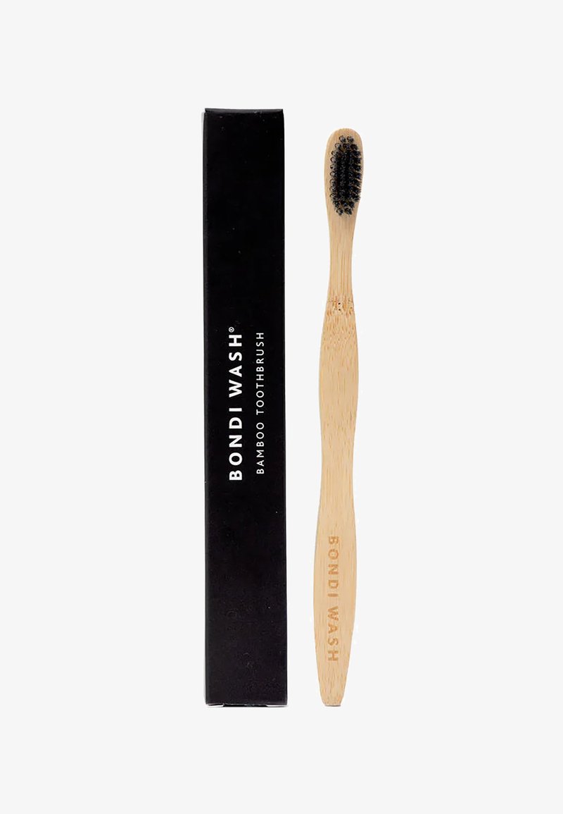 Brosse à dents en bambou avec un manche en bois lisse et des poils noirs, emballée dans une boîte noire étiquetée "BOND WASH."