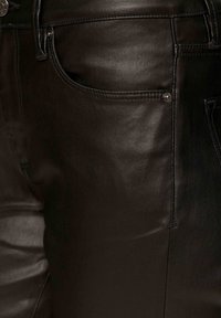 Czarne skórzane spodnie o gładkiej fakturze, z przednią kieszenią, subtelnym przeszyciem i metalowymi detalami.