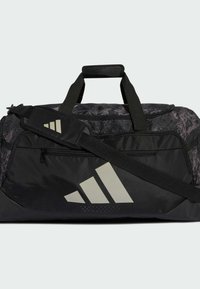 Bolsa deportiva negra con tejido texturizado, detalle con logotipo, correa de hombro ajustable y asas superiores para llevar de diversas maneras.