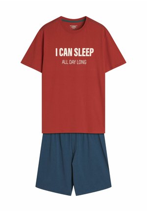 Czerwona bawełniana koszulka z białym napisem "MOGĘ SPAĆ CAŁY DZIEŃ" w połączeniu z niebieskimi, lekkimi szortami. Prosty krój, okrągły dekolt, casualowy fason.