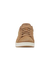 Ruskohi suede K-Swiss lenkkarit, joissa on yhteensopivat nauhat ja valkoinen kumipohja, nähtynä edestä valkoista taustaa vasten.