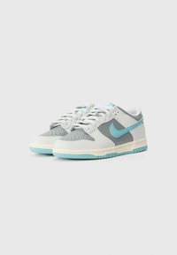 Sneaker in pelle grigia e bianca con una swoosh azzurro chiaro, pannelli testurizzati, perforazioni sulla punta e una suola in gomma azzurro chiaro.