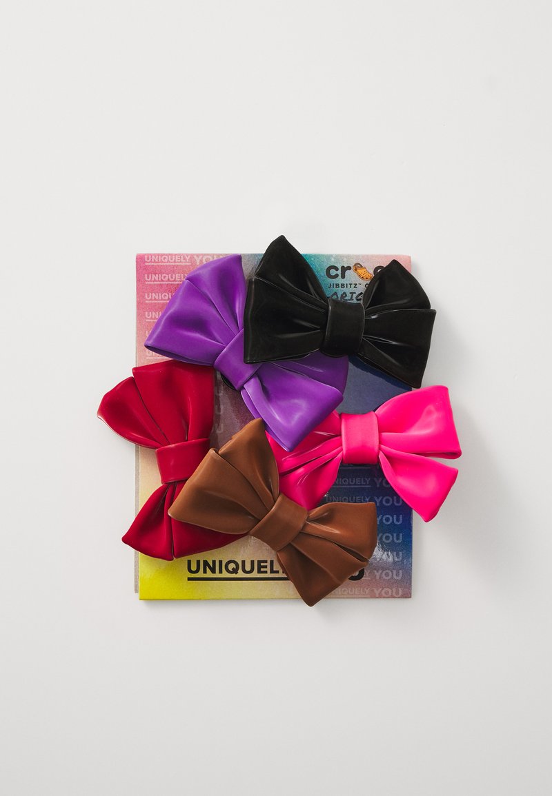 Σύνολο πέντε μεγάλων κορδελών σε μωβ, ροζ, κόκκινο, μαύρο και καφέ, κατασκευασμένες από γυαλιστερό υλικό, τοποθετημένες σε μια πολύχρωμη κάρτα.