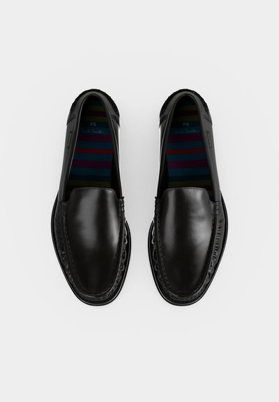 Paire de mocassins noirs en cuir à enfiler, avec bouts arrondis, coutures visibles et semelles intérieures rayées multicolores sur fond blanc.