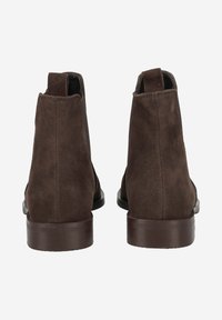 Bottines en daim marron avec une texture lisse, dotées d'un bout arrondi et d'un petit talon empilé marron foncé. Pas de matériel ou d'accents visibles.