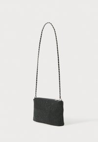 Piccola borsa da sera nera con superficie texturizzata e una lunga tracolla in argento, esposta su uno sfondo bianco.