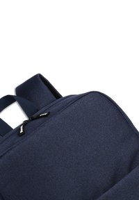 Sac à dos bleu marine en tissu texturé, doté d'une fermeture éclair et de bretelles doubles. Comprend un petit logo de marque sur la tirette de la fermeture.