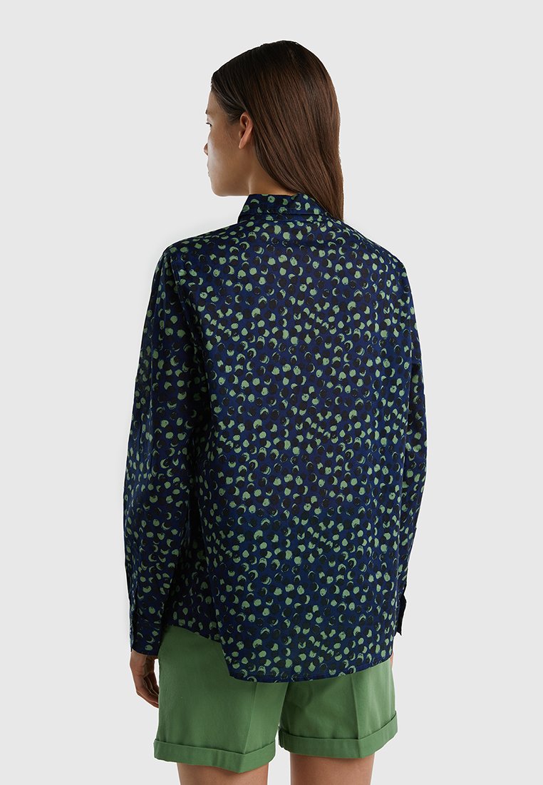 Camicia a maniche lunghe realizzata in tessuto leggero, con uno sfondo blu scuro decorato da motivi astratti verdi. Design del colletto classico.