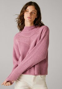 Roze gebreide trui met een hoge hals, uitgerust met gestructureerde patronen op de schouders en losse, uitgerekte mouwen. Ribgebreide manchetten en onderrand.