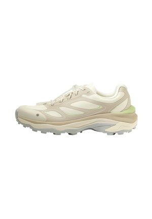 Sneaker basse beige e bianco sporco con pannelli in mesh, suola imbottita e suola esterna grigia scanalata, vista di lato su sfondo bianco.