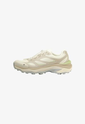Sneaker basse beige e bianco sporco con pannelli in mesh, suola imbottita e suola esterna grigia scanalata, vista di lato su sfondo bianco.
