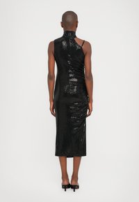 Black sequin dress with a high neck, one shoulder strap, and ruched detailing. Mid-length skirt, fitted silhouette, and smooth texture.