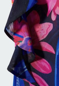 Tissu léger et transparent présentant un motif floral vibrant aux tons roses, bleus et noirs, avec une finition douce et texturée et un tombé fluide.