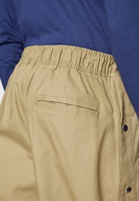 Nike Performance NBA PANT - Friluftsbukser - neutral olive/hyper crimson