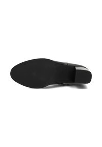 Chaussure à talons hauts noire avec une tige en cuir lisse et une semelle en caoutchouc texturé. Le talon a une forme carrée pour un soutien stable.