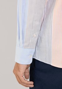 Wzorzysty klasyczny T-shirt w pastelowe niebieskie, pomarańczowe i białe paski; zapinane mankiety; miękka tekstura materiału; dopasowany krój.