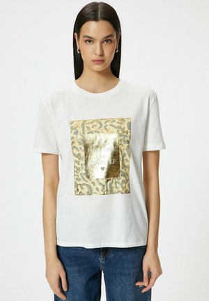 Hvid bomulds t-shirt med et guldfolie leopardprint kvadrat og teksten "Tag altid tid til dig selv." Korte ærmer og løs pasform.