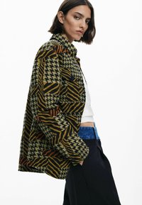 Vævet mønstret jakke i grøn, sort og orange med hundetand og zebra print, med knaplukning og en afslappet pasform.