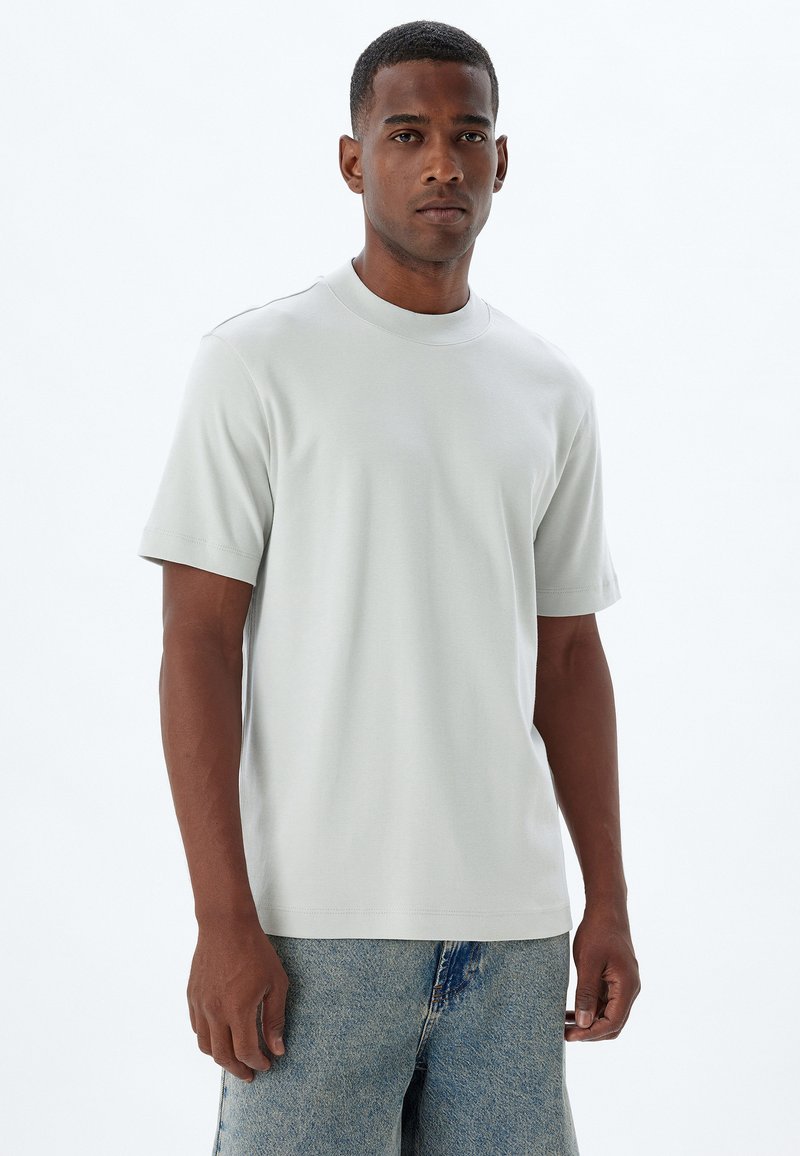 Lys grå kortærmet t-shirt lavet af blødt stof, med en rund halsudskæring og en afslappet pasform. Minimalistisk design uden synlige mønstre.