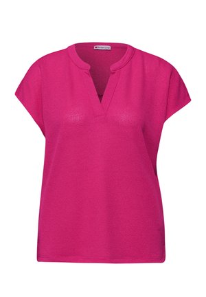 Haut tricoté à manches courtes de couleur rose vif avec un col en V et une coupe ample, conçu pour un usage décontracté.