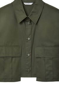 Chemise à manches courtes vert olive avec col pointu, fermeture à boutons sur le devant et deux poches poitrine. Tissu lisse avec un léger éclat.