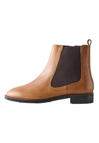 Botte Chelsea en cuir fauve avec des panneaux latéraux élastiques en marron foncé, bout arrondi et petit talon en caoutchouc noir. Dotée d'une languette à l'arrière.
