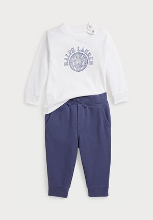 Conjunto de dos piezas: camisa de manga larga de algodón blanca con logotipo impreso en azul marino y pantalones de chándal azul marino con cordón y bolsillos laterales.