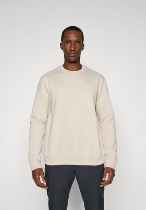 Beige sweatshirt featuring a round neckline, long sleeves, ribbed cuffs and hem, with a subtle logo on the chest. Smooth texture.