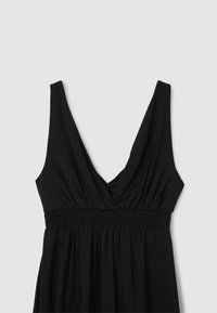Abito nero con scollatura a V profonda, corsetto arricciato con smock e gonna fluente. Realizzato in tessuto morbido e leggero.