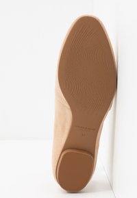 Semelle en daim beige avec une adhérence en caoutchouc texturé, marque "Vagabond Shoemakers", taille 37, photographiée sur fond blanc.