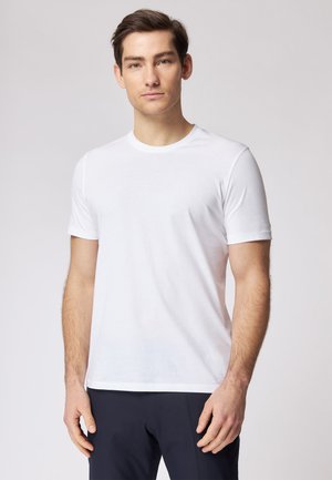 T-shirt blanc à manches courtes en tissu doux, avec un col rond classique et une coupe régulière. Texture lisse, design épuré.