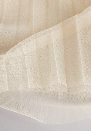 Beige pleated mesh-kangas, jolla on hieno, ilmava rakenne; pehmeä laskeutuvuus; kevyt, läpikuultava ulkonäkö; kevyt ja joustava.