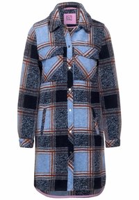 Vestido de camisa a cuadros en tejido de franela azul, negro y marrón. Presenta un cuello, cierre de botones, bolsillos en el pecho y mangas largas.