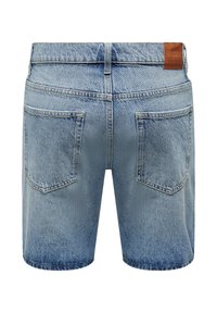 Un short en denim bleu clair avec une coupe droite, deux poches arrière et une légère décoloration près de l'ourlet. Patch en cuir avec logo au niveau de la taille.