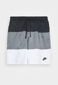 Černé, šedé a bílé šortky Nike s elastickým pasem a šňůrkou, s logem Nike na bílé části.