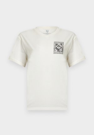 Hvit T-skjorte med korte ermer og et svart-hvitt rektangulært grafisk motiv med stilisert blomsterdesign og teksten "Billabong" på venstre bryst.