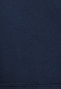 Marineblaues Gewebe mit einer glatten, strukturierten Oberfläche und einem gerillten Muster. Verfügt über einen sauberen Saum ohne sichtbare Logos oder Muster.