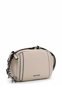 Piccola borsa a tracolla beige texturizzata con rifiniture nere, tracolla regolabile e charm in metallo con logo appesi sul lato.