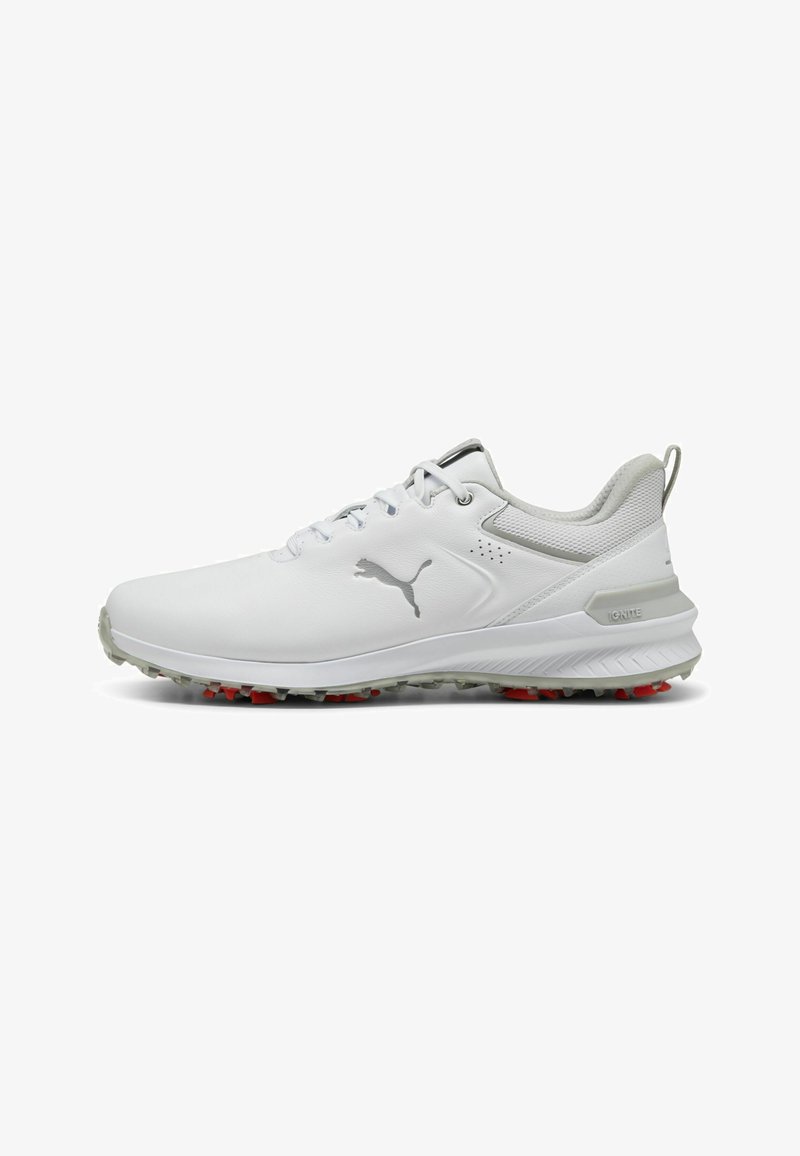 Chaussures de golf blanches avec un upper synthétique lisse, une semelle rembourrée, des pointes rouges et des détails gris au niveau du talon et du logo.