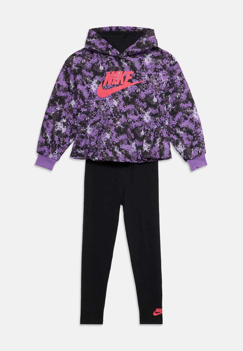 Haut à capuche Nike floral violet et noir avec des leggings noirs assortis, tous deux ornés de logos Nike rouges sur la poitrine et la cheville.